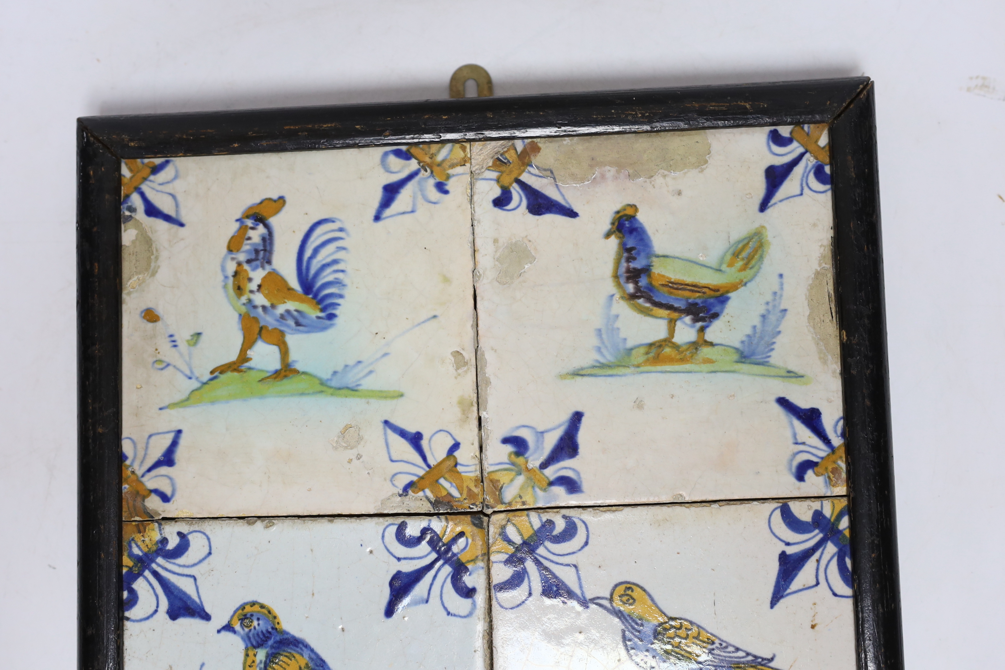 A 17th century Delft four-tile panel, polychrome-decorated with birds and with fleur-de-lys to corners (frame 28cm)